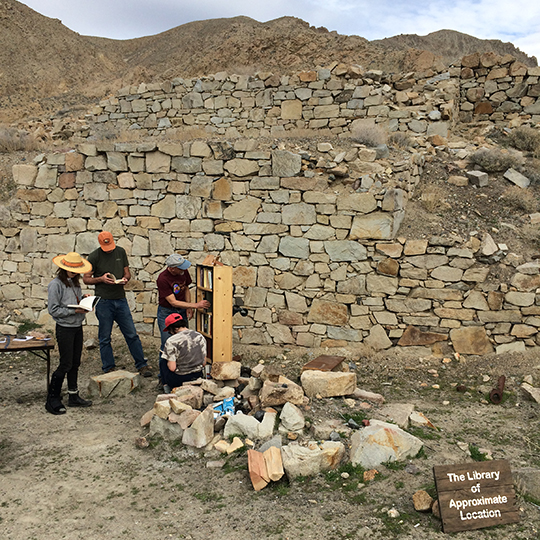 People reading books at a library in the desert.