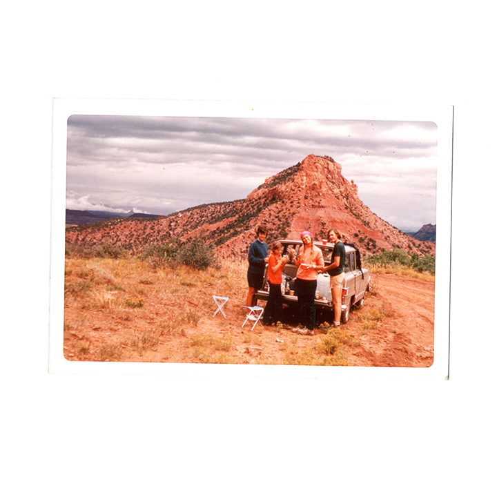 A photo of a family in front of a station wagon in the Utah Desert.